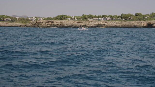 Boat cruise along the Mallorca coastline, small cove with anchored boats