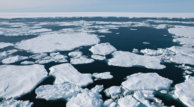 Vast expanse of fragmented ice floes drifting on dark, still water