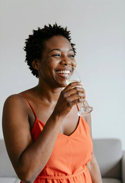 Celebration and joy, happy african american woman laughing with a glass of champagne at a party or social event