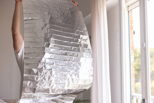 Man holding unrolled sun protection foil film for windows.