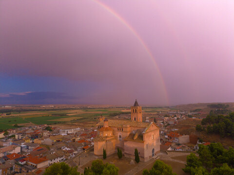 arco iris e iglesia en pueblo al atardecer