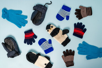 Different types of winter gloves and mittens on a blue background © Андрей Знаменский