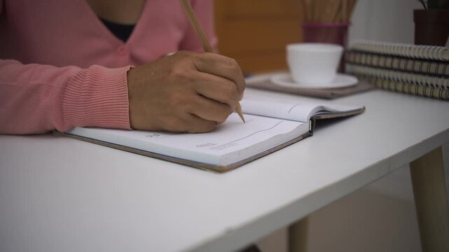 Planner plan Schedule Calendar and reminder agenda, work online at home. Man hand planning daily appointment and write business trip in diary book at office desk. 2026 Calendar reminder event concept.