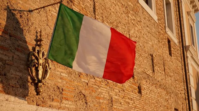 Italian flag waving in the wind against a historic brick wall at golden hour italy tricolour