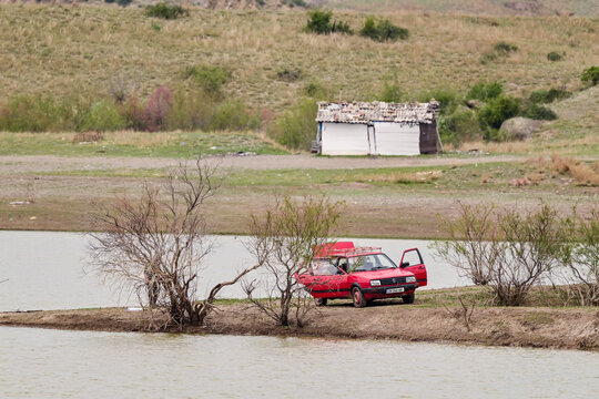 Red 1980s/1990 VW Jetta II in a hilly landscape in Georgia; a classic "youngtimer" car during a fishing trip in nature, Caucasus region, Georgia 18.04.2025