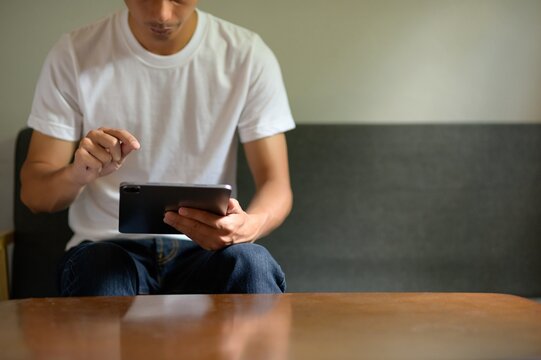 Young Man Using Tablet at Home, Casual Environment on Couch