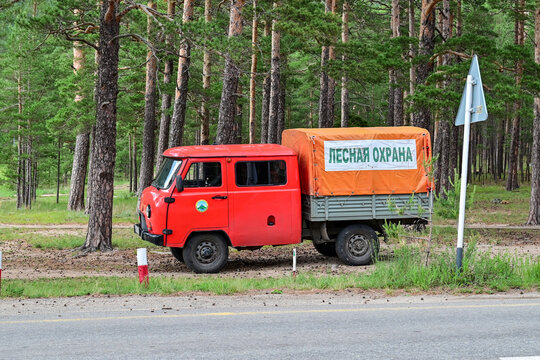 Red UAZ-39094 Buhanka Farmer pickup truck with forest protection agency markings parked at the edge of the forest in Burabai; off-road utility vehicle, Aqmola, Kazakhstan 17.05.25