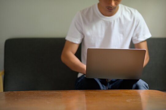 Casual Man Using Laptop While Sitting on Couch at Home