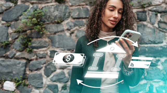 Online payment process with a person checking their phone near a stone wall