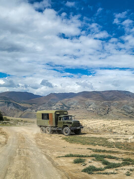 Green ZIL-131 6x6 off-road truck with a box body driving along a track in the mountainous landscape of the Altai region; Soviet off-road vehicle, Altai Republic, Russia 01.08.2025