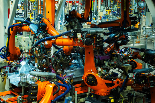 Industrial Robots Welding Car Body in Automotive Manufacturing Factory

