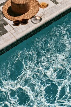 Relaxing poolside with hat, sunglasses, and chilled drink