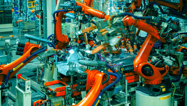 Industrial Robots Welding Car Body in Automotive Manufacturing Factory

