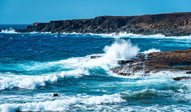 Ocean waves crashing against a broad rocky shore