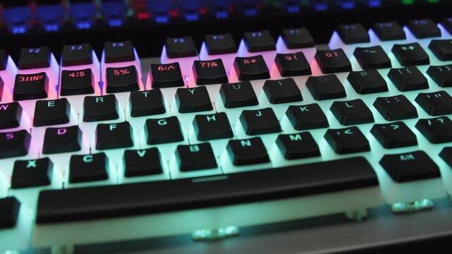 Close-up of gaming computer keyboard with LED backlight in dark room