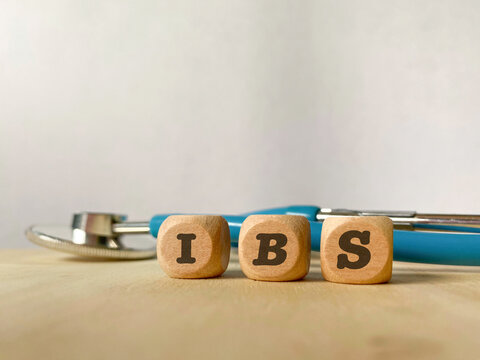 Wooden blocks spelling IBS beside a stethoscope, representing irritable bowel syndrome, digestive health, gastrointestinal disorders and medical diagnosis.