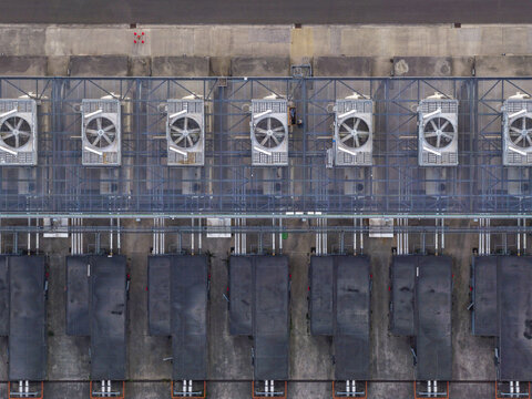 Aerial view of an AI modern data center featuring rows of industrial cooling fans and metal infrastructure on a concrete surface in Belgium.