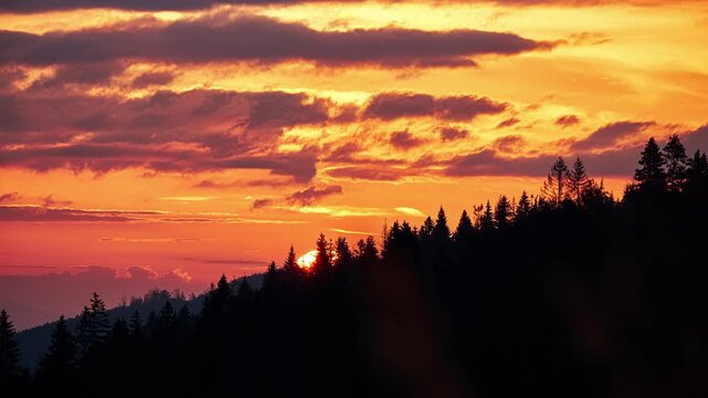 Timelapse of Glowing Sun Setting Behind Forested Mountain Silhouette