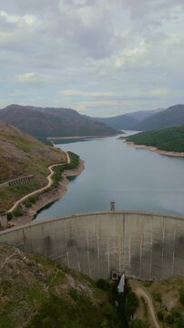 Vertical aerial drone footage of Vilarinho das Furnas dam and reservoir in Peneda-Geres National Park, Portugal
