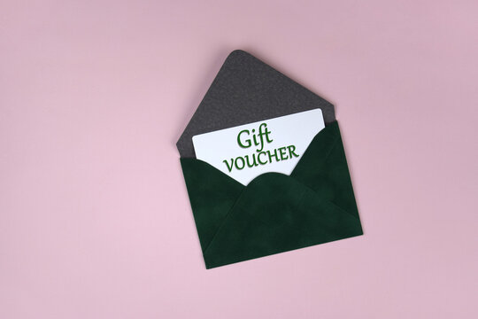 Gift voucher in a green envelope on a light background