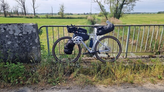 Gravel bike with bikepacking bags leaning against a bridge railing over a river in the Altm&uuml;hl Valley; a cycling trip and micro-adventure on the Altm&uuml;hl Valley Cycle Path, Bavaria, Germany