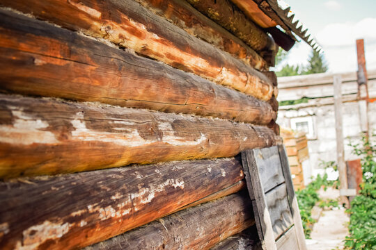 Weathered log wall of an old wooden countryside house with natural wood texture