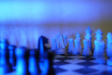 Close-up of a chess piece on a chessboard in dim blue light. World Chess Day. International Chess Day. July 20.  © PANCASONA CREATION