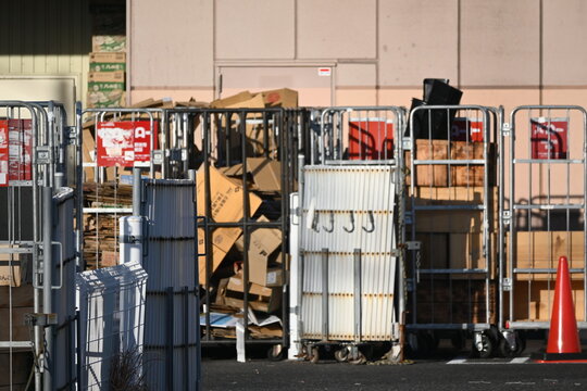 屋外に並ぶ折りたたみコンテナとカゴ車