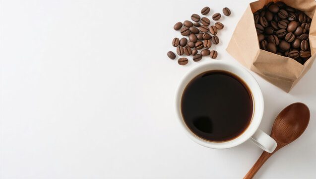 Top view of a white coffee cup and roasted bean inside a craft paper bag. A wooden spoon sits on a clean white background with ample copy space