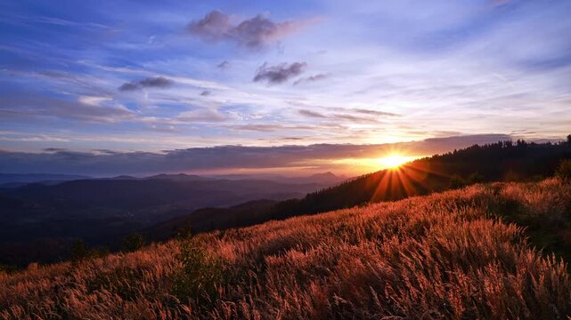 Timelapse of Golden Sunrise Over Mountain Valley and Grassy Meadow