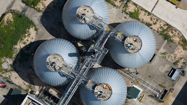 Aerial view of industrial storage tanks connected by metal walkways and pipes at a facility in Reading, England, United Kingdom.