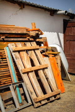 Large storage area with old lumber, construction materials and a weathered bathtub in a rural yard