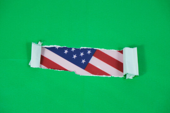 An American flag behind torn green paper. Great for any US holiday like Memorial Day, July 4th, Labor Day, Presidents Day, or as a political background.
