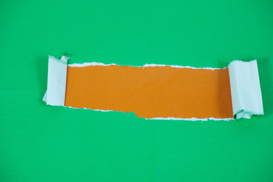 Torn paper with space for text against an orange background. The torn green paper peels back, revealing the orange paper underneath.
