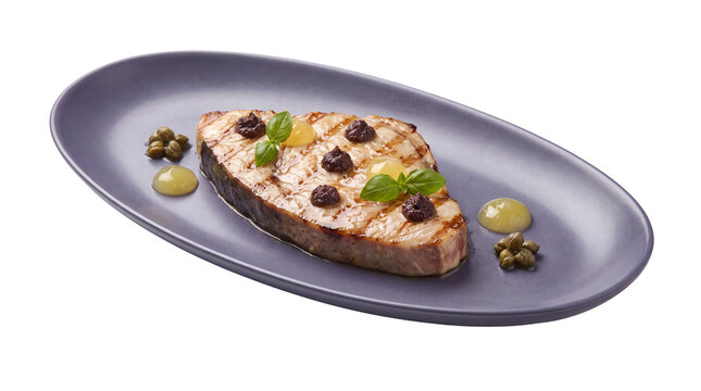 Grilled red snapper fillet with capers and mint, gourmet fish dinner on purple oval plate, isolated seafood dish with green garnish and sauce dots