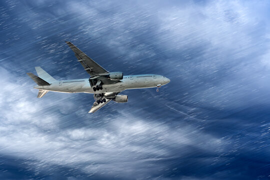 Airplane airliner is approaching for landing in difficult weather conditions: heavy rain and dark clouds with wind.