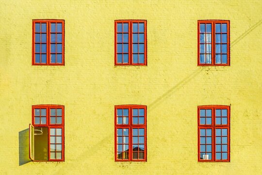 Yellow building facade with vibrant red windows