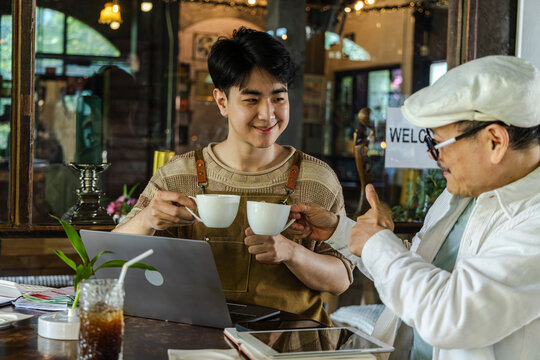 Modern small business digital management concept with entrepreneur reviewing data on laptop while coordinating with team member, using technology for workflow planning, efficiency, and performance