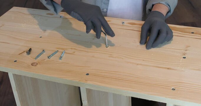 A carpenter assembling a wooden bookshelf