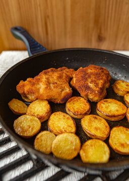 Breaded chicken schnitzel with pan-roasted potato slices.