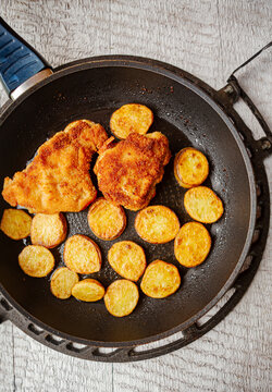 Breaded chicken schnitzel with pan-roasted potato slices.