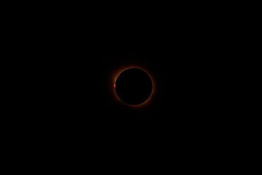 Close view of the total solar eclipse of August 12, 2026 photographed from Burgos, Spain. A bright red solar prominence is clearly visible beside the dark lunar silhouette