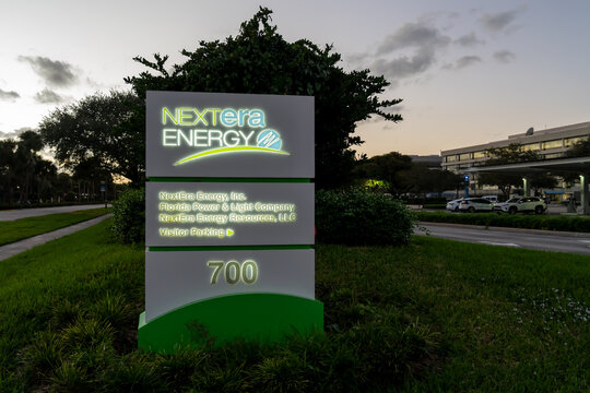 Toronto, ON, Canada - January 2, 2022: In the dusk of the corporate entrance sign at the headquarters of NextEra Energy in Juno Beach, Florida, USA. NextEra Energy is an American energy company. 