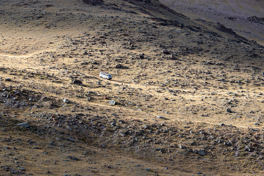 Classic UAZ van descending a steep rocky mountain slope of Sailughem range, Altai