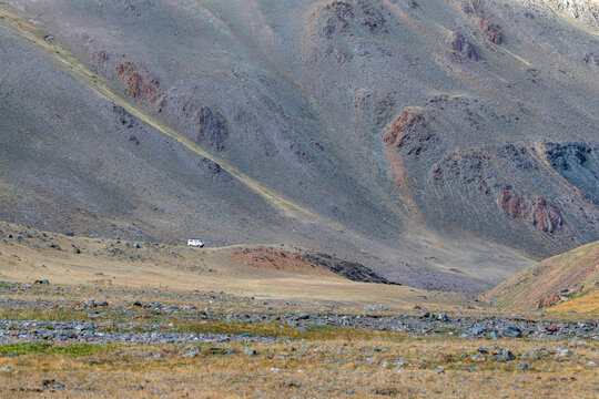 Classic UAZ van off-road driving on a mountain slope of Sailughem range, Altai Mountains