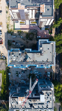 Aerial view of residential construction featuring a tower crane and apartment buildings, illustrating urban growth and new housing supply in San Donato Milanese, Lombardy, Italy.