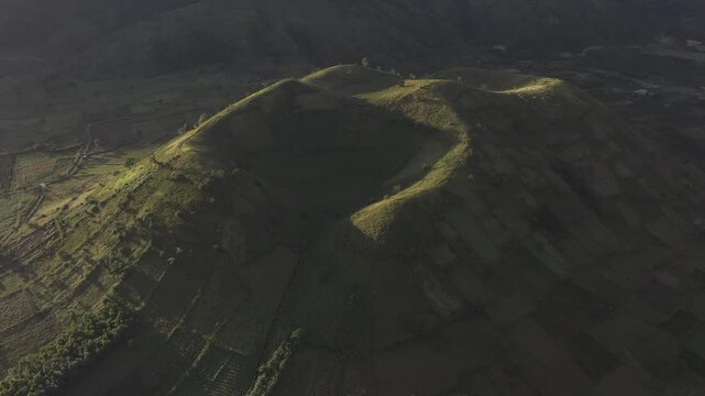Aerial drone view of Chu Dang Ya Volcano at sunset in Bien Ho, Gia Lai, Vietnam, revealing dramatic volcanic terrain, lush highlands and a stunning golden sky.