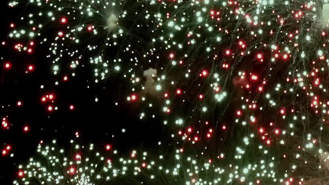 Brilliant explosions ignite the inky canvas of Night. Crimson, emerald, and ivory sparks dance, creating a mesmerizing spectacle during this festive celebration.