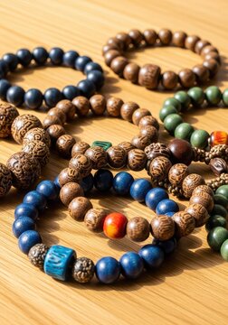 A collection of handcrafted wooden bead bracelets resting on a smooth, pale timber surface, showcasing natural textures and organic beauty, surface, pale, eco-friendly