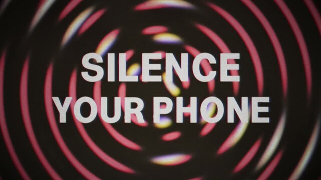 Hypnotic spiral patterns pulse with red concentric rings as bold Silence your phone text message emerges. Retro grindhouse cinema aesthetic with psychedelic optical effects for theater announcements.
